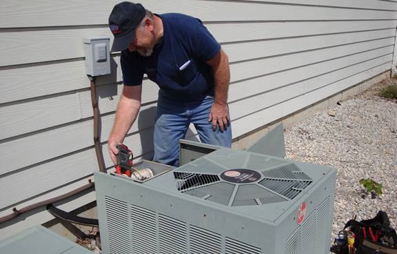 Trusted HVAC contractor servicing residential AC unit outdoors