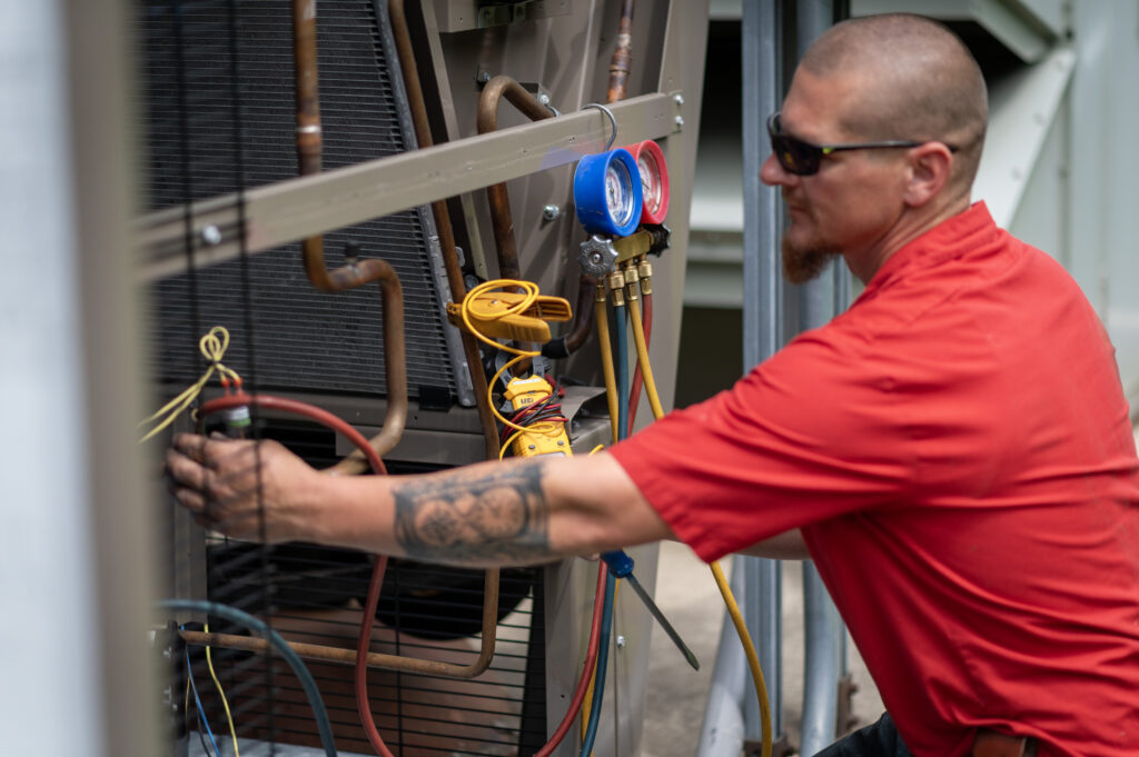 HVAC Master technician tuning residential air conditioner condenser outdoors