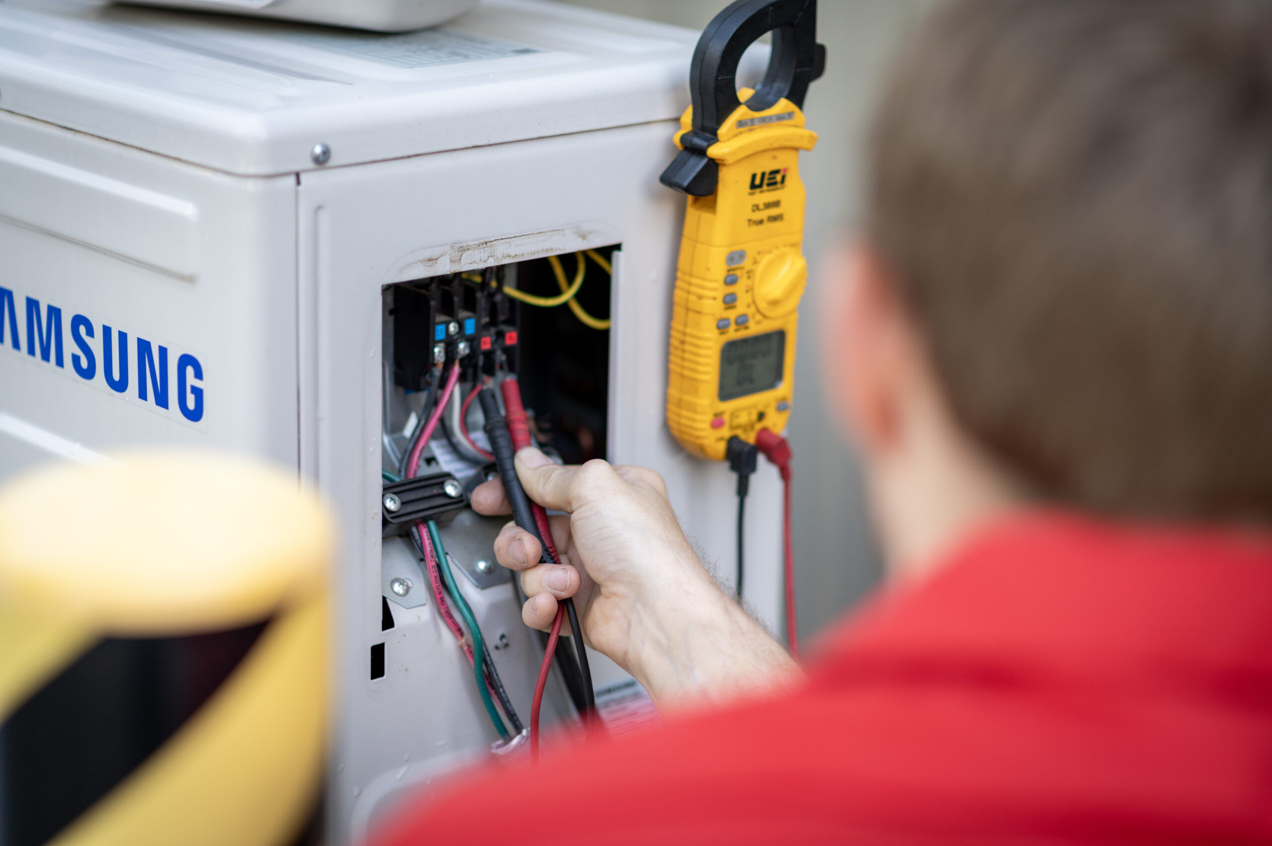 HVAC Master Heating & Air Conditioning LLC technician servicing central air conditioner condenser outdoors