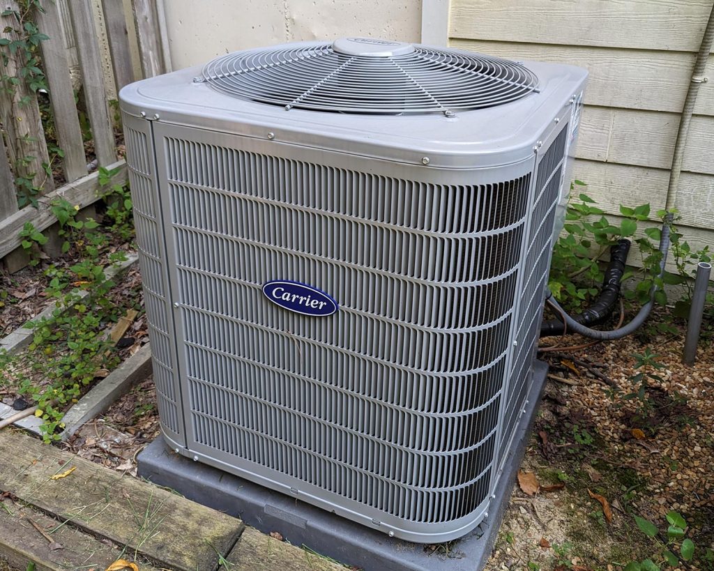 HVAC Master Heating & Air Conditioning LLC technician servicing Carrier air conditioning unit outdoors